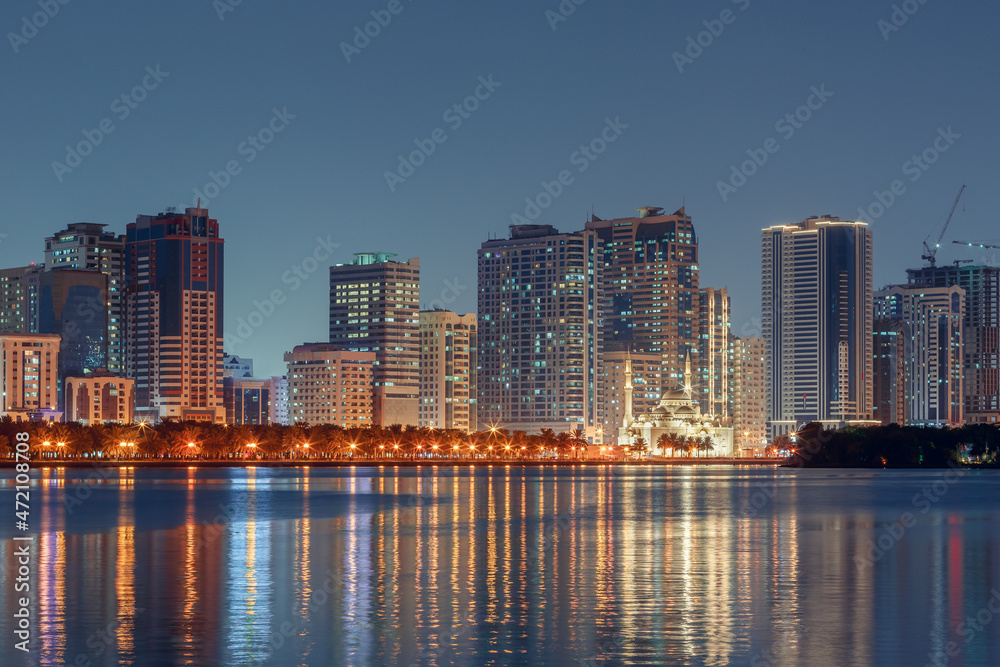 Obraz premium The tallest towers in the Emirates and their reflection on the lakes at night, Dubai, Sharjah