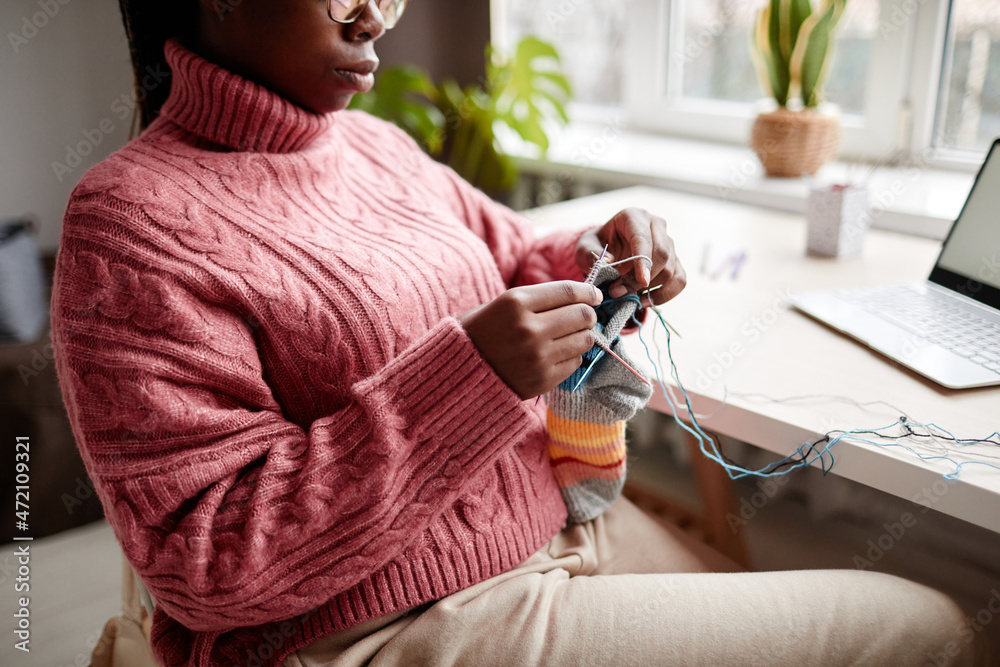 Cropped portrait of young African-American woman knitting at home and enjoying cozy weekend, copy space