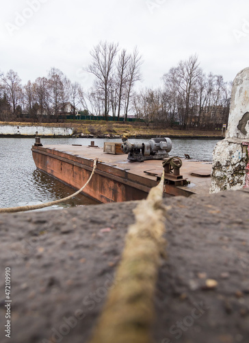 The ropes are stretched from the bollards to the pontoon on the water. photo