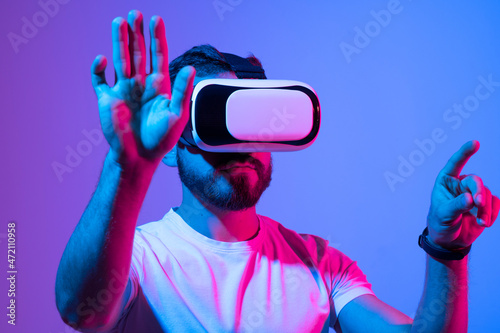 Man wearing virtual reality goggles. VR technology concept. Augmented reality, future technology concept. VR. Neon light. © Volodymyr