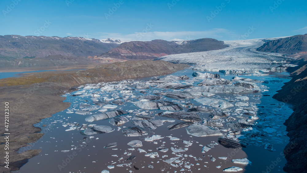 Bick blocks of glacier ice broken from big glacier at hoffell, iceland, floating in brown water.ž