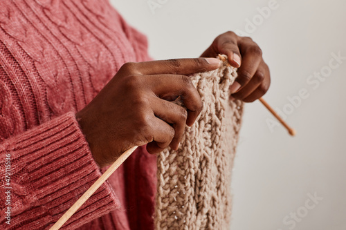 Фотография Close up of unrecognizable African-American woman knitting scarf, copy space