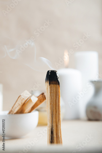 Palo Santo bar smokes close-up and copy space. Ritual cleansing with sacred ibiocai, meditation, aromatherapy with incense and candles..