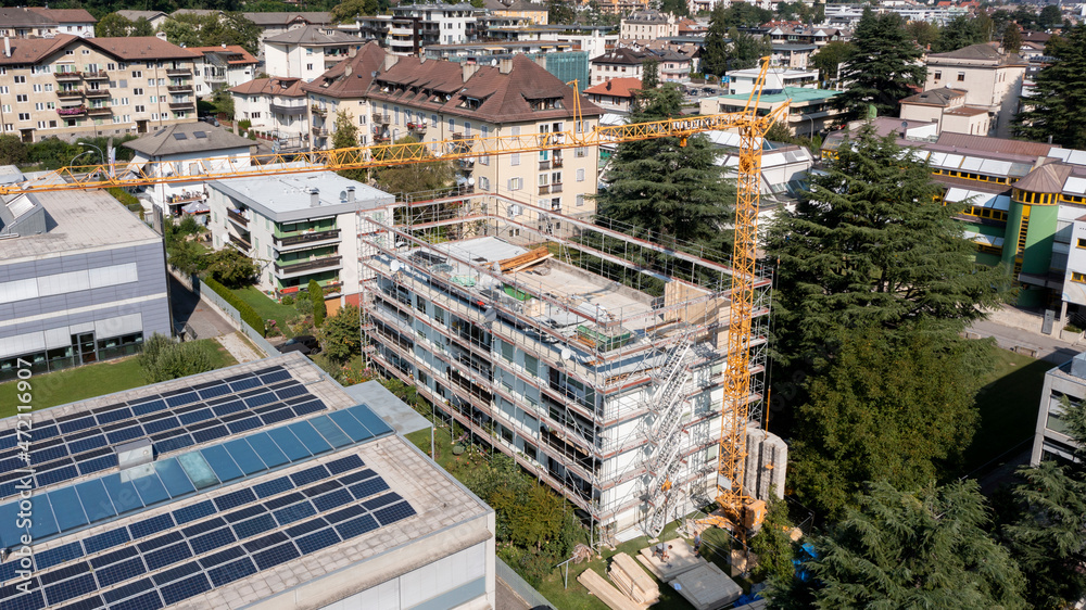 Fototapeta premium Aerial view of a renovation and elevation of an old residential building or family condominium in the city. Building facilitation bonus for higher energy class.