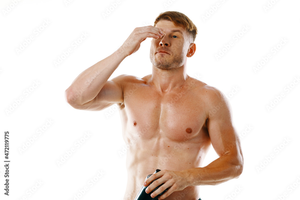 Fototapeta premium a man an athlete with a pumped-up body drinks from a bottle