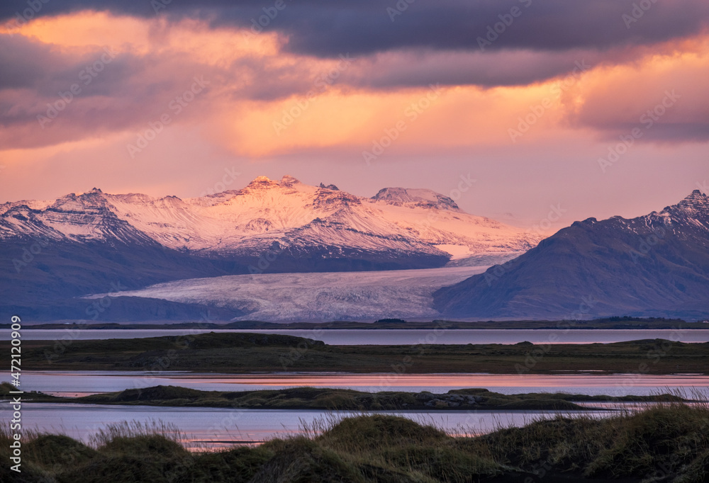 Obraz premium Sunrise Stokksnes cape sea beach, Iceland. Amazing nature scenery, popular travel destination. Autumn grass on black volcanic sand dunes.