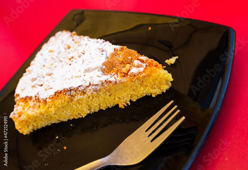 Piece of traditional Spanish almond cake Tarta de Santiago decorated with powdered sugar.. photo