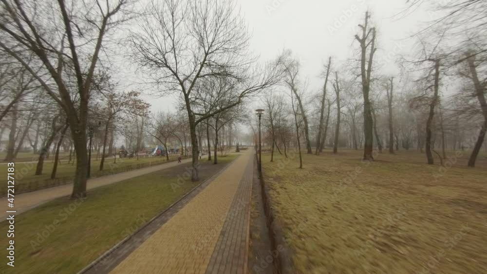 City park on a cloudy autumn day. Aerial view. A park with trees, paths, people and benches. Flying through the city square City park on a cloudy autumn day. Aerial view. A park with trees, paths, people and benches. Flying through the city square