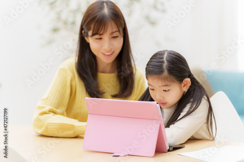 タブレットを使って学習する女の子とお母さん