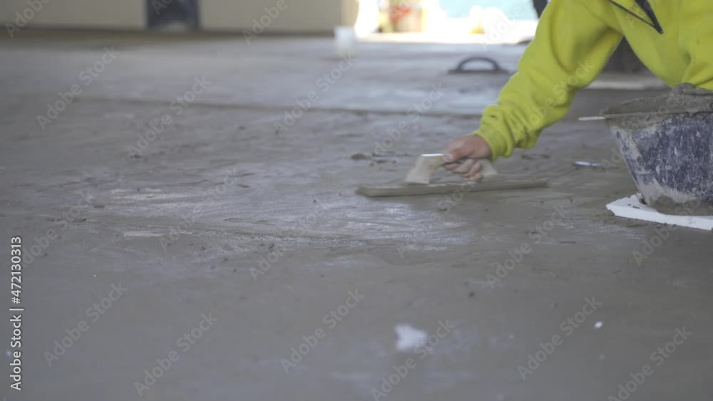 Construction labourers levelling plastered floor using flat trowel and cement manually. Constructing floor of a house. 4k video. Construction labourers levelling plastered floor using flat trowel and cement manually. Constructing floor of a house. 4k video.