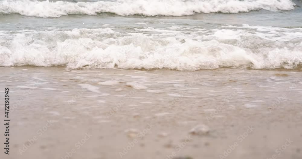 Fearless waves by the shore. A view of fearless sea waves crash the sandy shore in the cold summer. Fearless waves by the shore. A view of fearless sea waves crash the sandy shore in the cold summer.