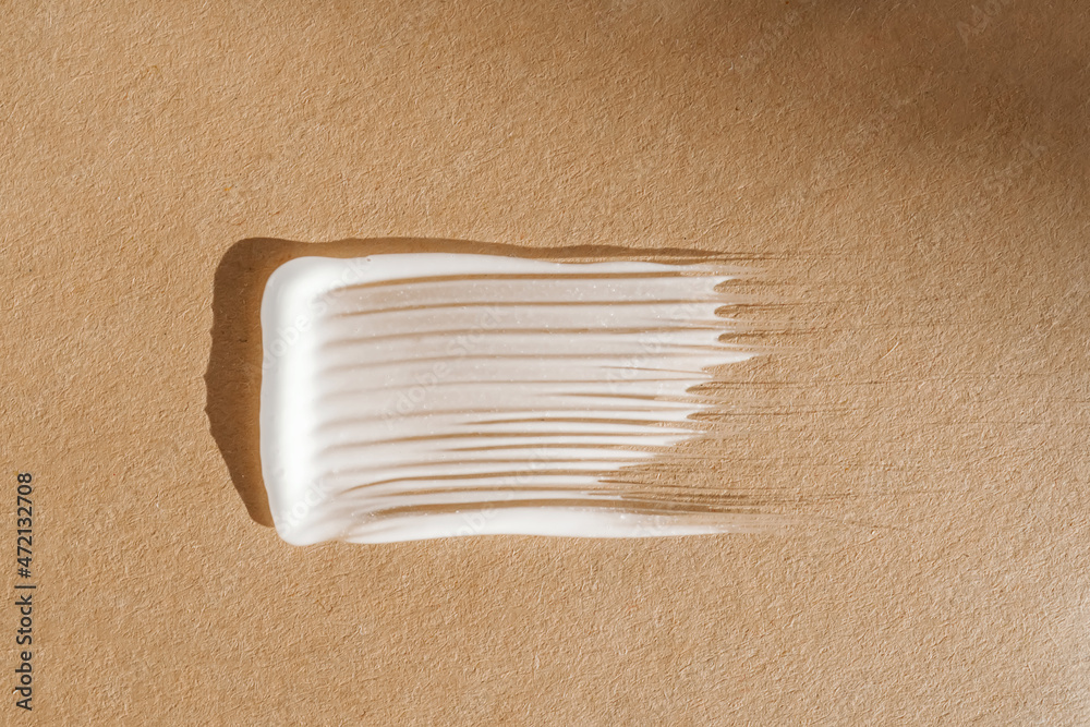 White cream texture on a beige background. White cream texture on a beige background.