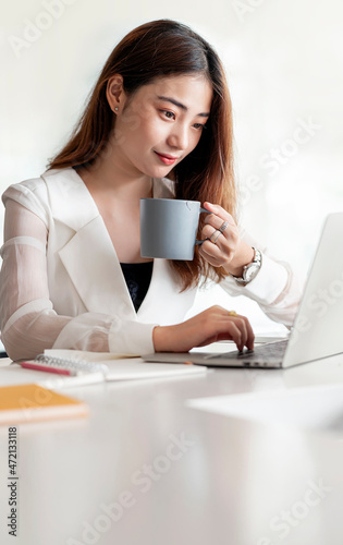 Portrait of asian woman holding mug working at office.