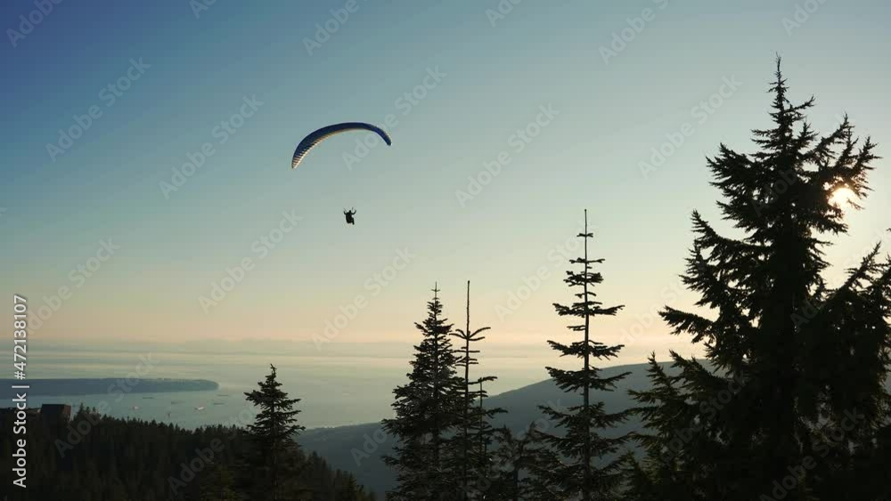 paraglider flying over grouse mountain with the city of Vancouver in the background, British Columbia, Canada in 4K