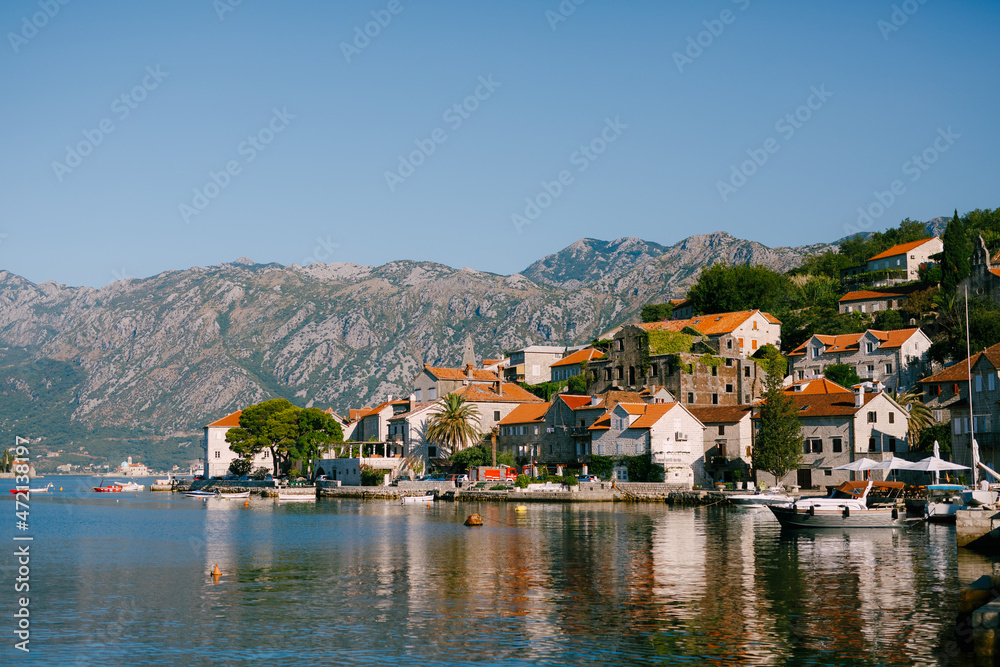 Ancient buildings with red roofs on the Perast coast. Montenegro