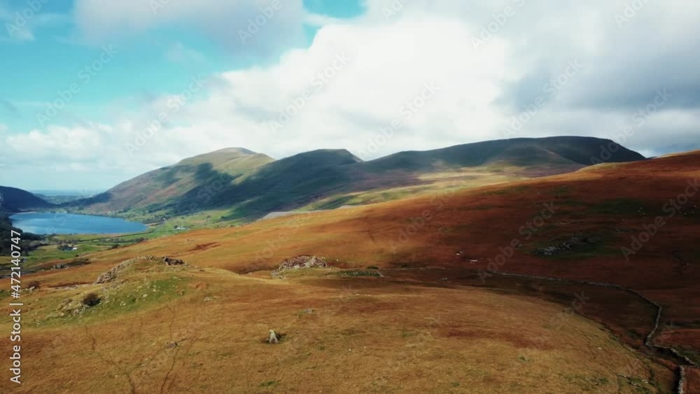 Aerial rotation right from lake to burnt orange grass covered hills to Snowdonia Mountain.Snowdonia,Wales,UK Aerial rotation right from lake to burnt orange grass covered hills to Snowdonia Mountain.Snowdonia,Wales,UK