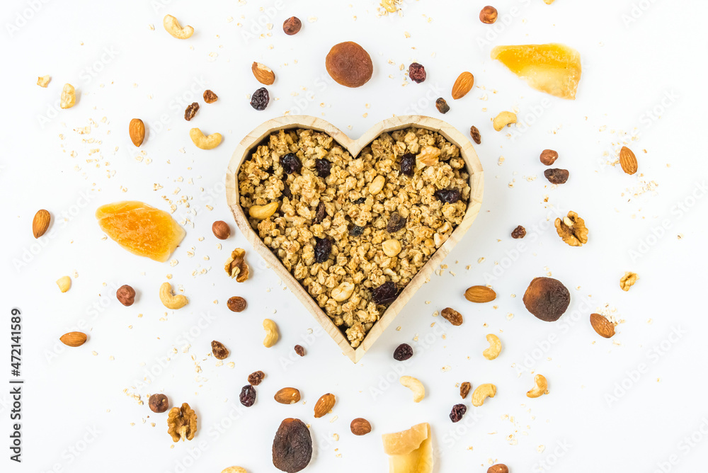 Top view of a heart shaped bow full of crunchy granola. Healthy eating concept.