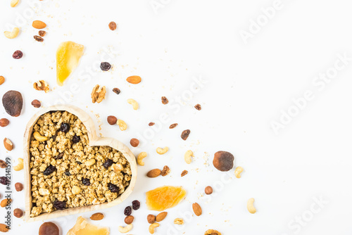 Top view of a heart shaped bow full of crunchy granola. Healthy eating concept. Copy space.