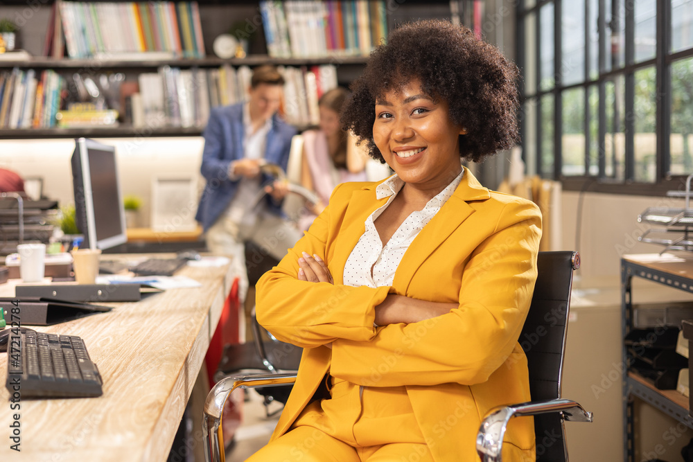 Young African American female architect working in an office.Portrait of a confident black businesswoman with all african american team in working room. Young African American female architect working in an office.Portrait of a confident black businesswoman with all african american team in working room.