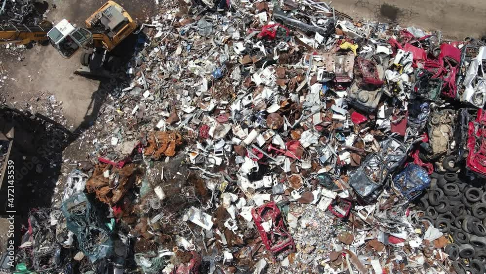 Aerial View of Scrapyard and Loader, Massive Hill of Metal and Machine. Birdseye Top Down Drone Shot Aerial View of Scrapyard and Loader, Massive Hill of Metal and Machine. Birdseye Top Down Drone Shot