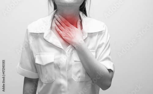 Asian woman using hand touch throat with pain, sore throat and sickness in an inflaming.