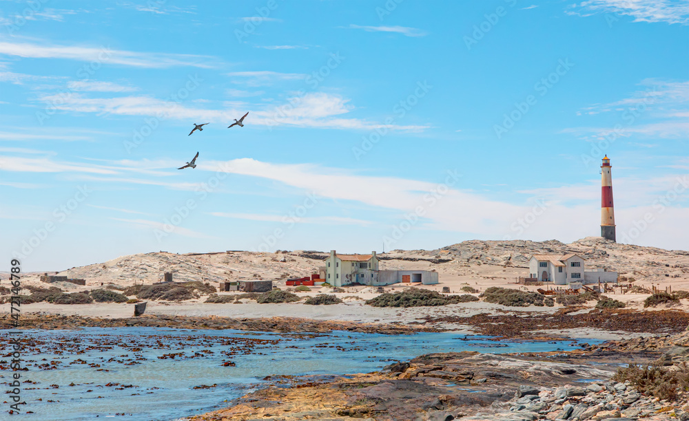 Amazing red and white lighthouse near Diaz Point with three migratory birds fly in the blue sky -  Lüderitz, Namibia 