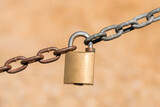 Locked padlock on rusty chain