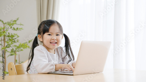 パソコンにいたずらして遊ぶ4歳の子供（育児・子育て）. © polkadot