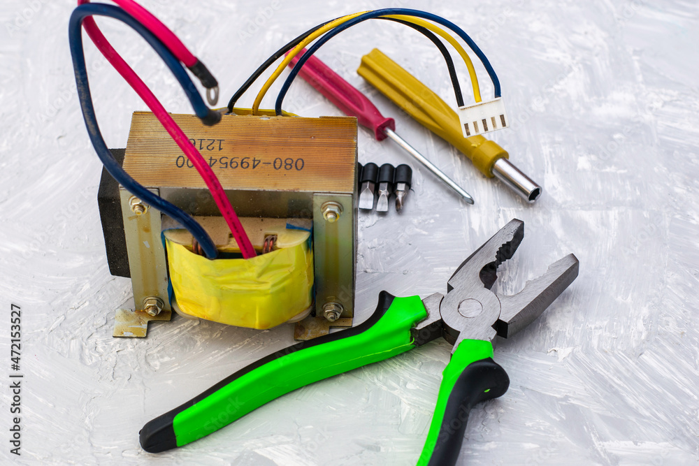 pliers electric transformer and screwdrivers on the table surface