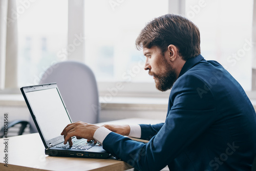 businessmen in the office at the desk in front of a laptop career official