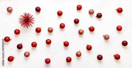 Xmas red shades balls flat lay on white background. Small baubles scattered on card top view.
