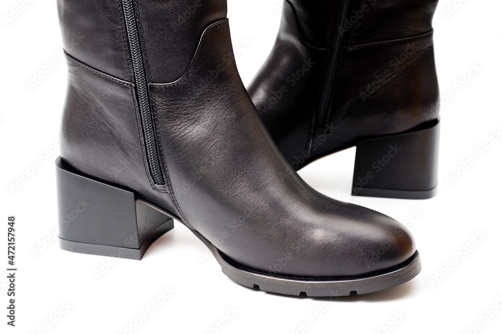 Black leather women’s boots fastened with a zipper. Background for shoes.