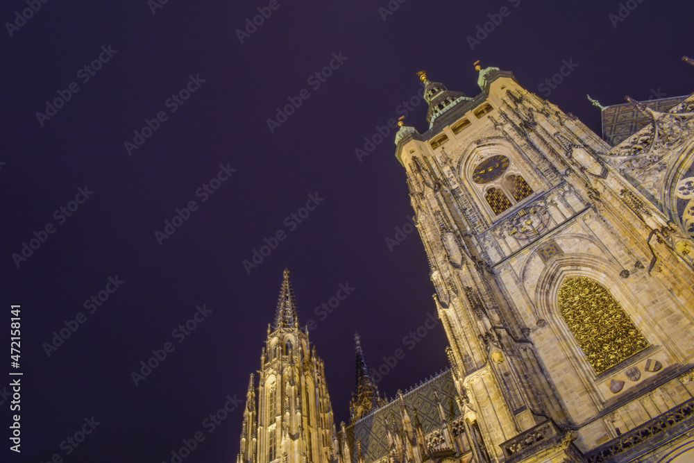 Fototapeta premium Cathedral with a clock rising into the night sky