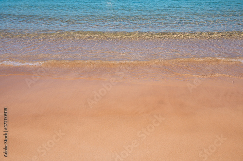 Beach background. Calm beautiful ocean wave on sandy beach. Sea view from tropical sea beach.