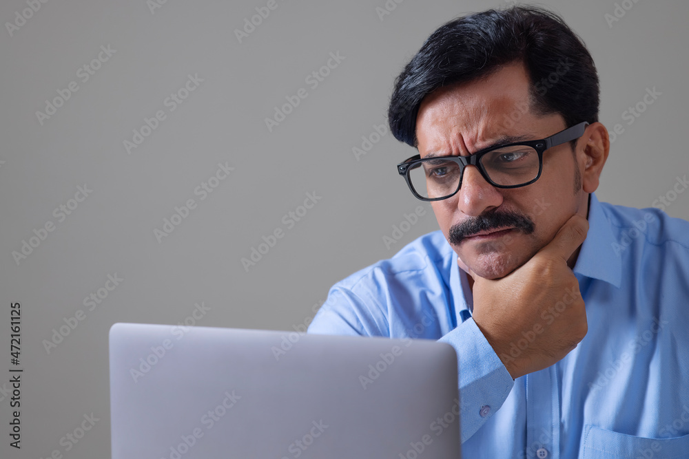 Man with his hand on chin concentrating on work Man with his hand on chin concentrating on work