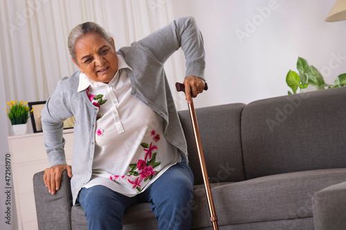 Senior woman trying to stand alone with the help of walking stick