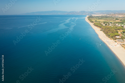 Aerial view of beautiful sea and beach at sunny day, seascape and hill mountain on backgrond, Simeri Mare, Calabria, Southern Italy