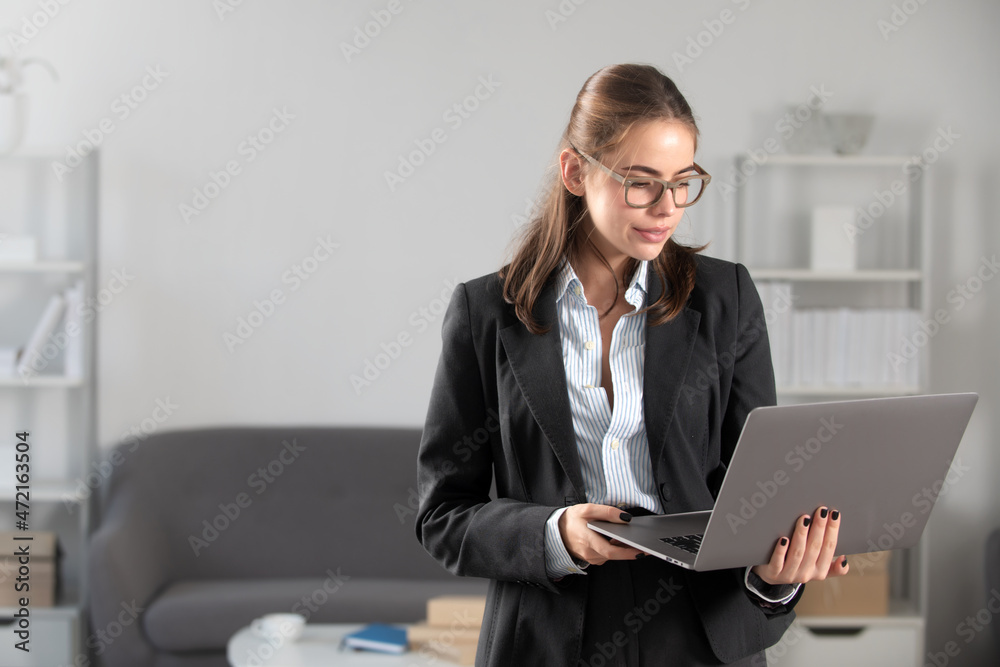 Young businesswoman in glasses working on laptop with too much work in office. Secretary girl. Young businesswoman in glasses working on laptop with too much work in office. Secretary girl.