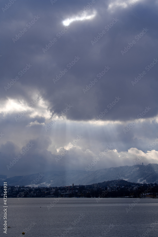 Beautiful dramatic blue cloudy sky with sunbeams over City of Zürich on a late autumn day. Photo taken November 29th, 2021, Zurich, Switzerland.