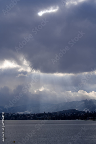 Beautiful dramatic blue cloudy sky with sunbeams over City of Zürich on a late autumn day. Photo taken November 29th, 2021, Zurich, Switzerland. © Michael Derrer Fuchs