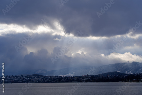 Beautiful dramatic blue cloudy sky with sunbeams over City of Zürich on a late autumn day. Photo taken November 29th, 2021, Zurich, Switzerland.