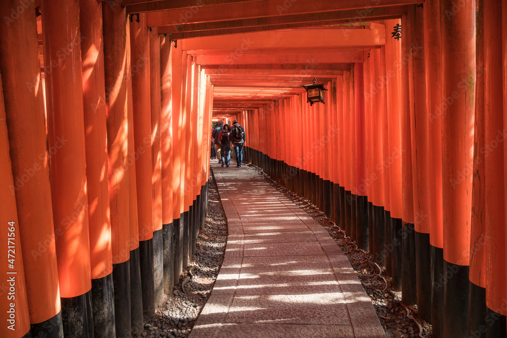 Fototapeta premium People visit Fushimi Inari Taisha, the Shinto shrine located in Fushimi-Ku, Kyoto, Japan. Senbon Torii is an impressive pathway with about a thousand torii gates.