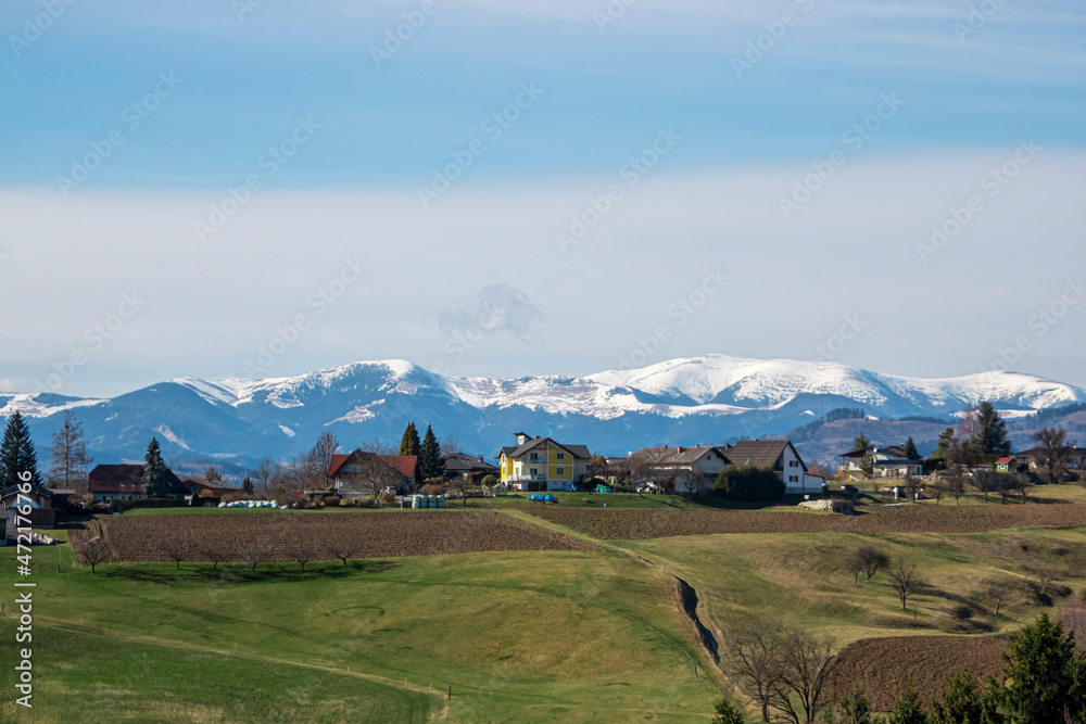 Panorama of a village in Austria against the background of snow-capped mountains in winter.