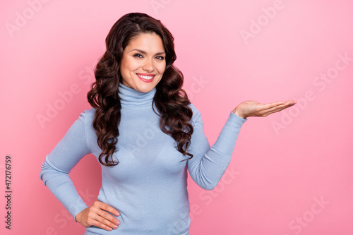 Photo of dreamy adorable lady dressed blue pullover holding arm empty space isolated pink color background
