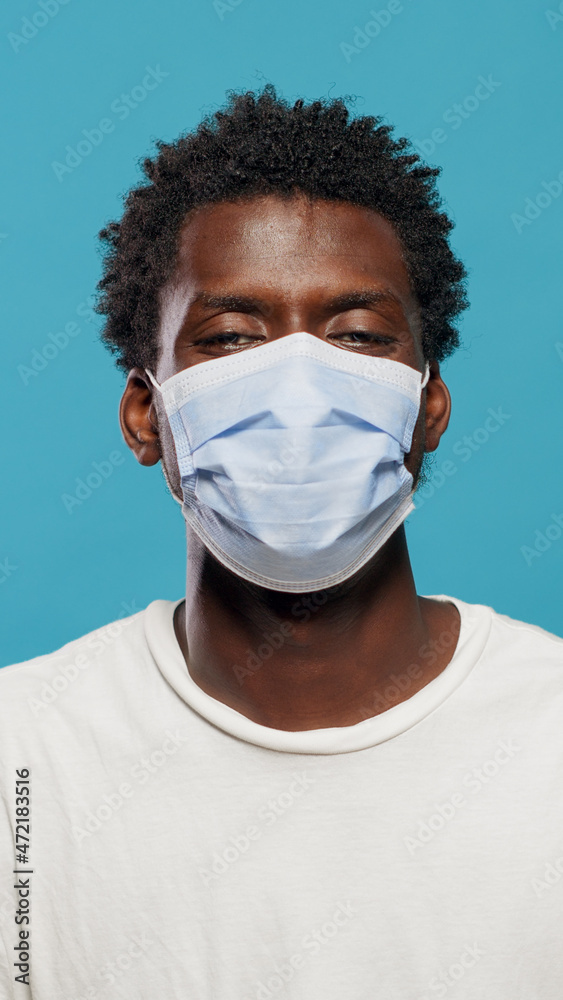 Portrait of african american man wearing face mask to protect from coronavirus in studio. Close up of black person looking at camera while having protective mask on face over background. Portrait of african american man wearing face mask to protect from coronavirus in studio. Close up of black person looking at camera while having protective mask on face over background.