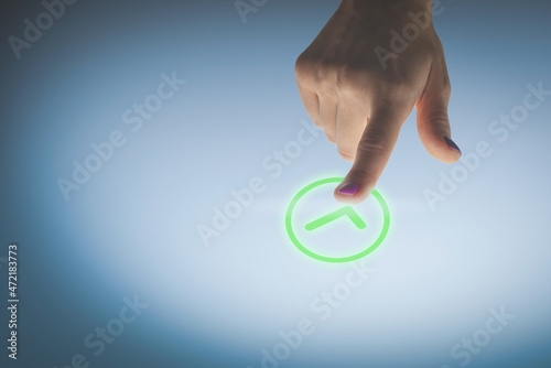 Woman hand pressing a green validation button, image concept of approval.