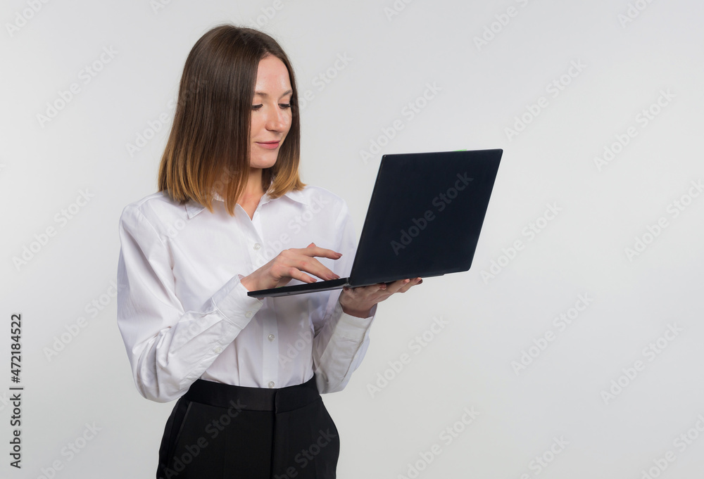 Portrait of young business woman using on laptop computer isolated over white background, copy space Portrait of young business woman using on laptop computer isolated over white background, copy space
