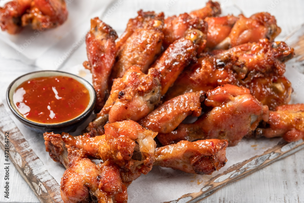 Chicken wings with sriracha sauce on wooden table