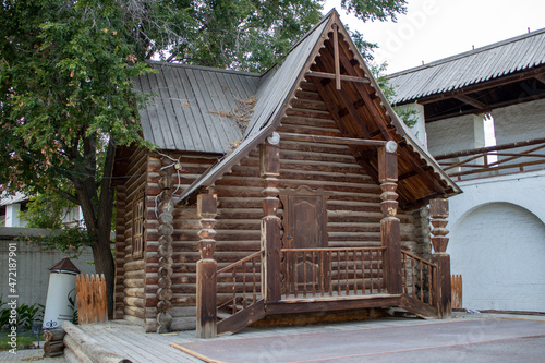 Wooden historic old hut. Astrakhan. House in the courtyard of a white castle. © Ra