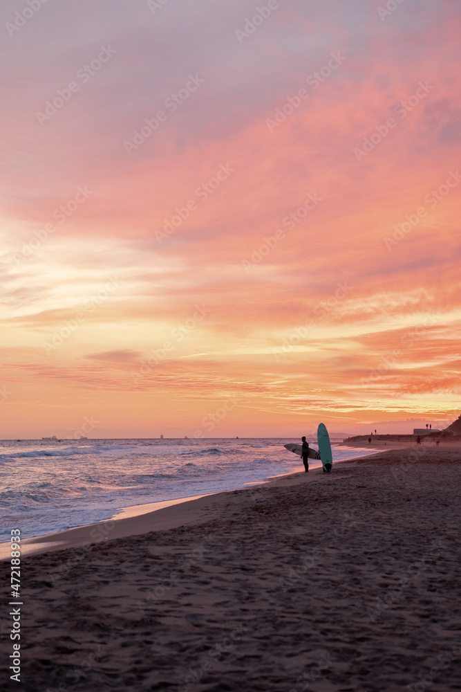 Puesta de sol en la playa de Altafulla con surfistas de fondo